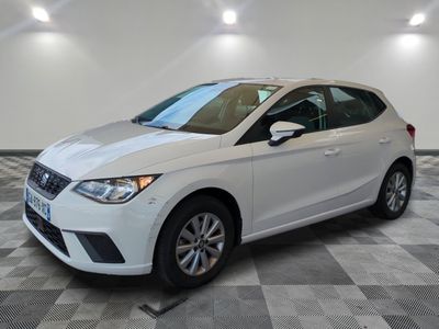 a white car is parked in a room with checkered flooring
