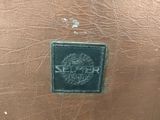 a close up of a leather bag with a logo on it