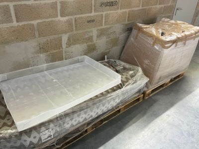 un matelas et une boîte posés sur une palette dans une pièce