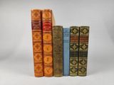 trois livres sont alignés sur une surface blanche