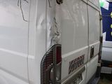 a white van that has been vandalized and is parked in the grass