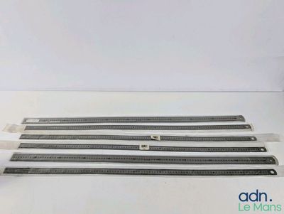 quatre règles de tailles différentes posées sur une surface blanche