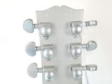 a close up of a guitar head on a stand