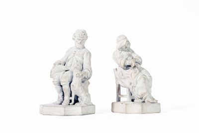deux figurines d'un homme et d'une femme assis sur un banc
