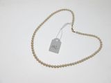 un gros plan d'un collier de perles muni d'une étiquette
