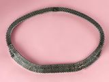 a black and white snake skin choker on a pink background