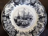 a black and white plate with a picture of a ship on it