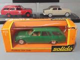 three toy cars in a display case on a table