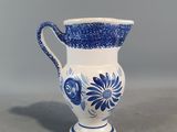 vase bleu et blanc orné de fleurs, sur un fond gris