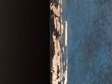 a close up of a blue door with peeling paint on it