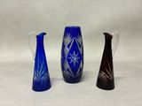 deux vases bleus et un vase noir sur fond blanc
