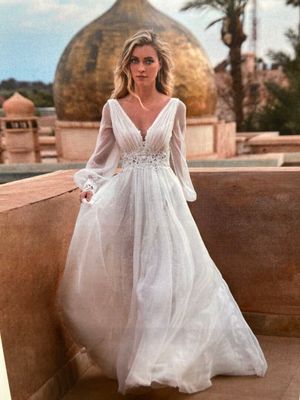 a woman in a wedding dress standing on a balcony
