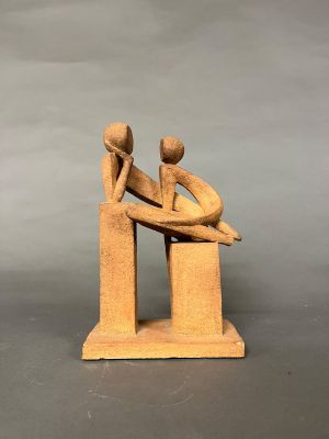 sculpture en bois représentant un homme et une femme assis sur un banc