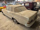 many old cars parked in a garage with a lot of rust