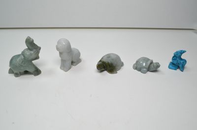 cinq petites figurines d'animaux sur un fond blanc