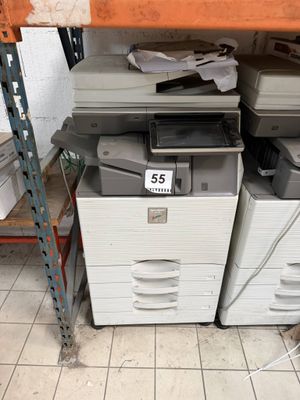 a stack of printer ' s sitting on a shelf in a store
