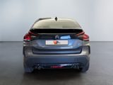 the rear end of a blue car in a white room