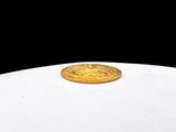 a gold coin sitting on top of a white table
