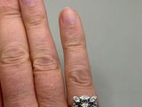 a woman ' s hand with a diamond ring on it