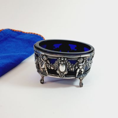 a blue cloth and a silver bowl on a white table