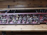 un banc en bois sur lequel est sculpté un groupe de personnes