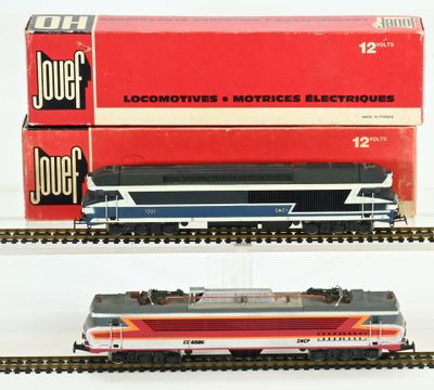 two model trains on display on a white surface