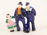 three figurines of a man and a woman standing next to each other