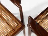 two wooden chairs with cane backrests on a white background