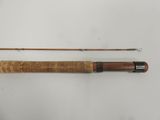 an old fishing rod with a wooden handle on a white surface