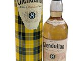 a bottle of glendulan whisky next to a canister