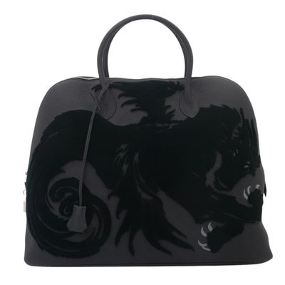 a close up of a black handbag with a dragon on it