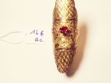 a small gold bug with a red bead on it