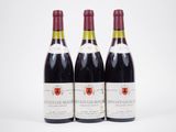 trois bouteilles de vin sont alignées sur une surface blanche