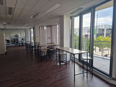 une pièce équipée de tables et de chaises, avec vue sur la ville