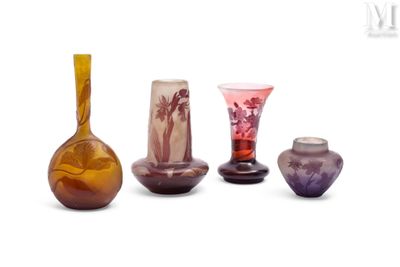 cinq vases en verre de couleurs différentes posés sur une surface blanche