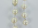 une paire de boucles d'oreilles en perles et diamants sur fond blanc