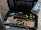 une boîte à outils contenant des outils, posée sur le sol