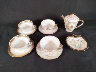cinq tasses et une soucoupe posées sur une table noire