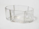 a clear glass container with a silver handle on a white surface