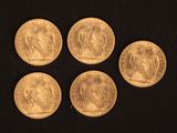 six souverains d'or de tailles et de formes variées sur un fond noir