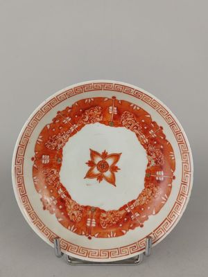 une assiette orange et blanche ornée d'un motif floral