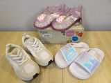 three pairs of baby shoes on a table next to a box of shoes