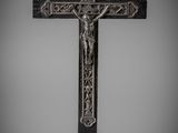 une croix en argent surmontée d'un crucifix, posée sur un socle en marbre