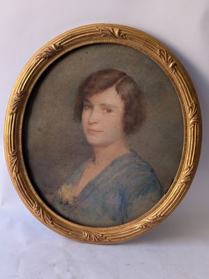 an old picture of a woman in a blue dress in a gold frame