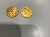 deux pièces d'or posées sur une table blanche