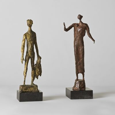 deux statues en bronze représentant une femme et un homme debout l'un à côté de l'autre