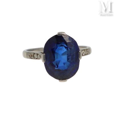 une bague ovale sertie d'un saphir bleu et de diamants, en or blanc 18 carats