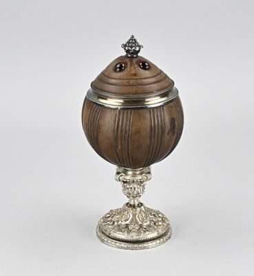 une urne ancienne en argent et en bois, munie d'un couvercle et posée sur un socle