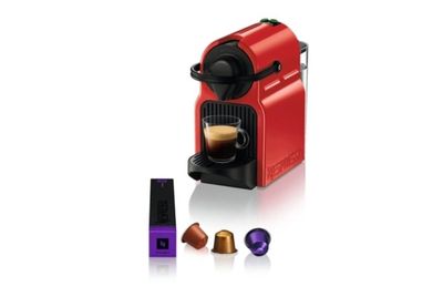 une machine Neso rouge à côté d'une tasse de café