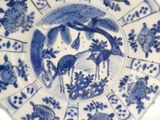 a blue and white plate with birds and flowers on it